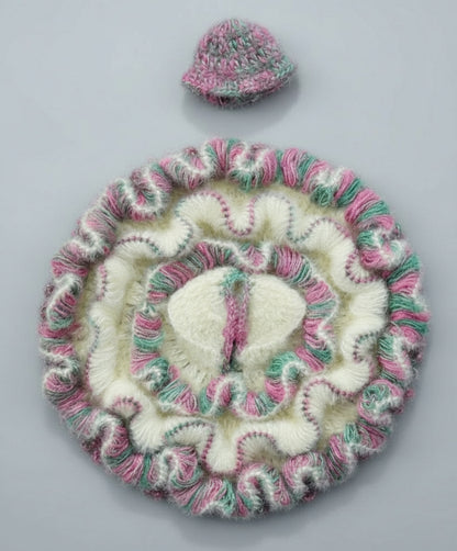 Knitted hat and coaster set with pink and green patterns on a gray background