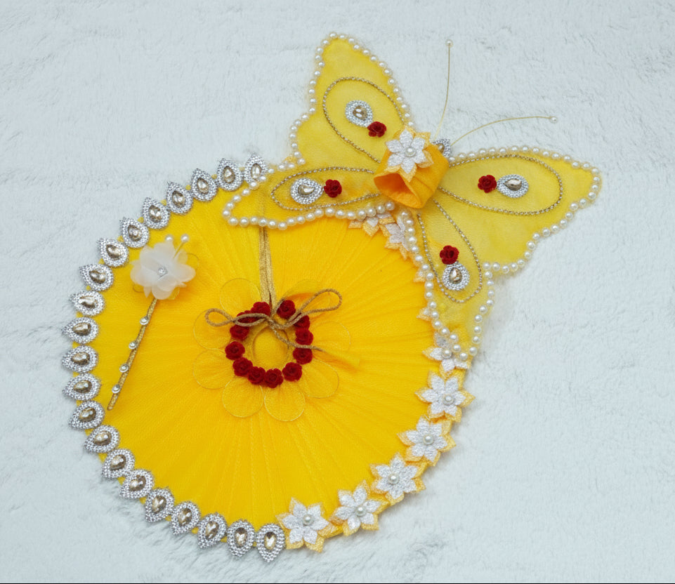 Decorative yellow butterfly with embellishments on a light gray background